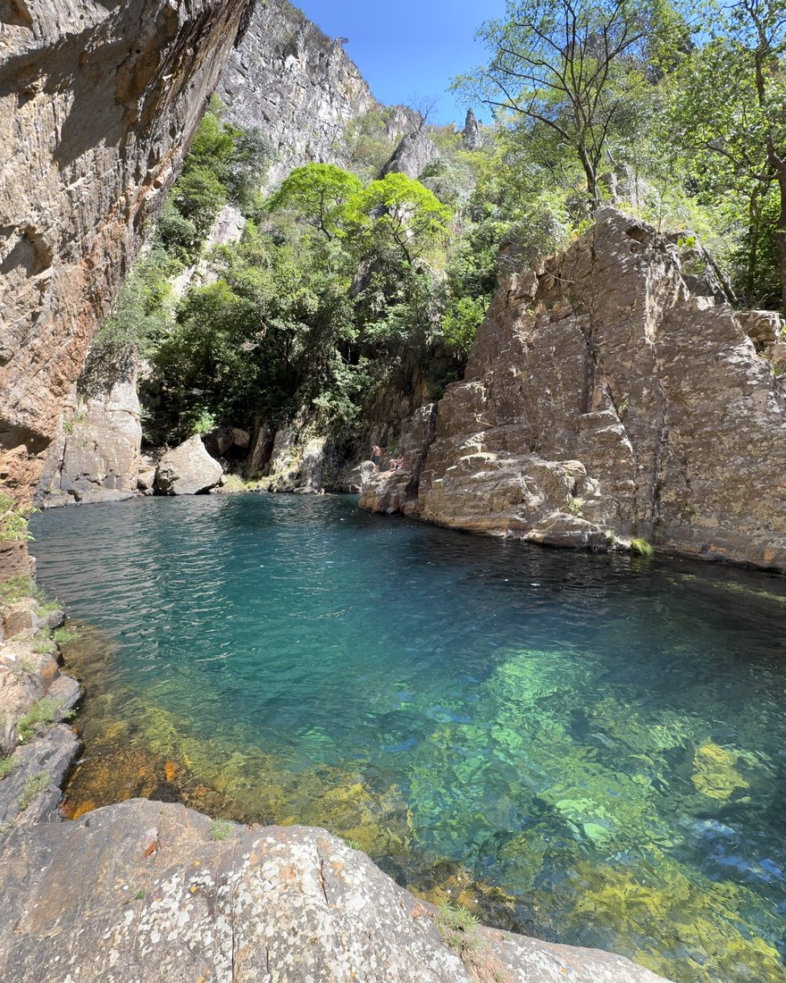 Poço azul-esmeralda profundo entre paredões de pedra de um cânion
