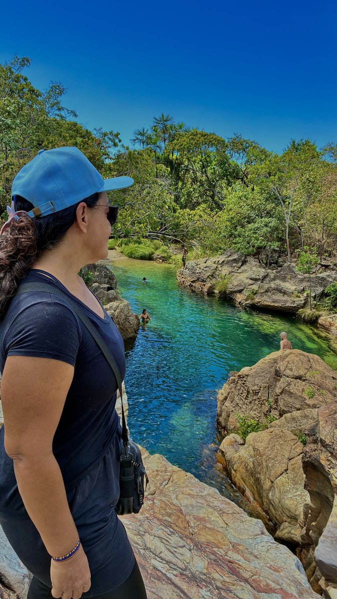 Guia observando rio de água verde do alto das pedras