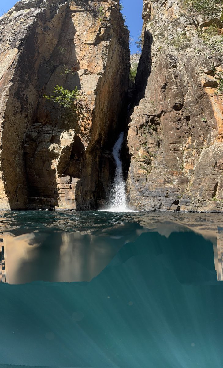 Cachoeira caindo entre altos paredões de rocha de um cânion estreito