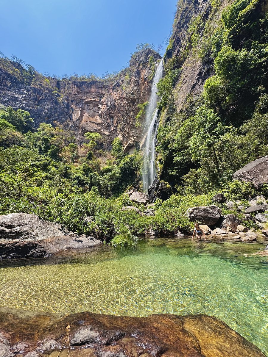 Queda d'água fina descendo paredão de pedra