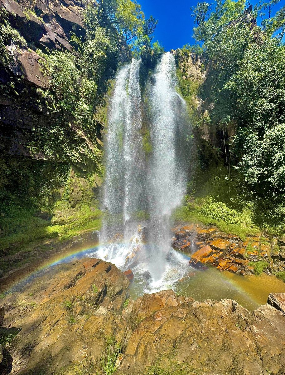 Cachoeira volumosa com arco-íris na base