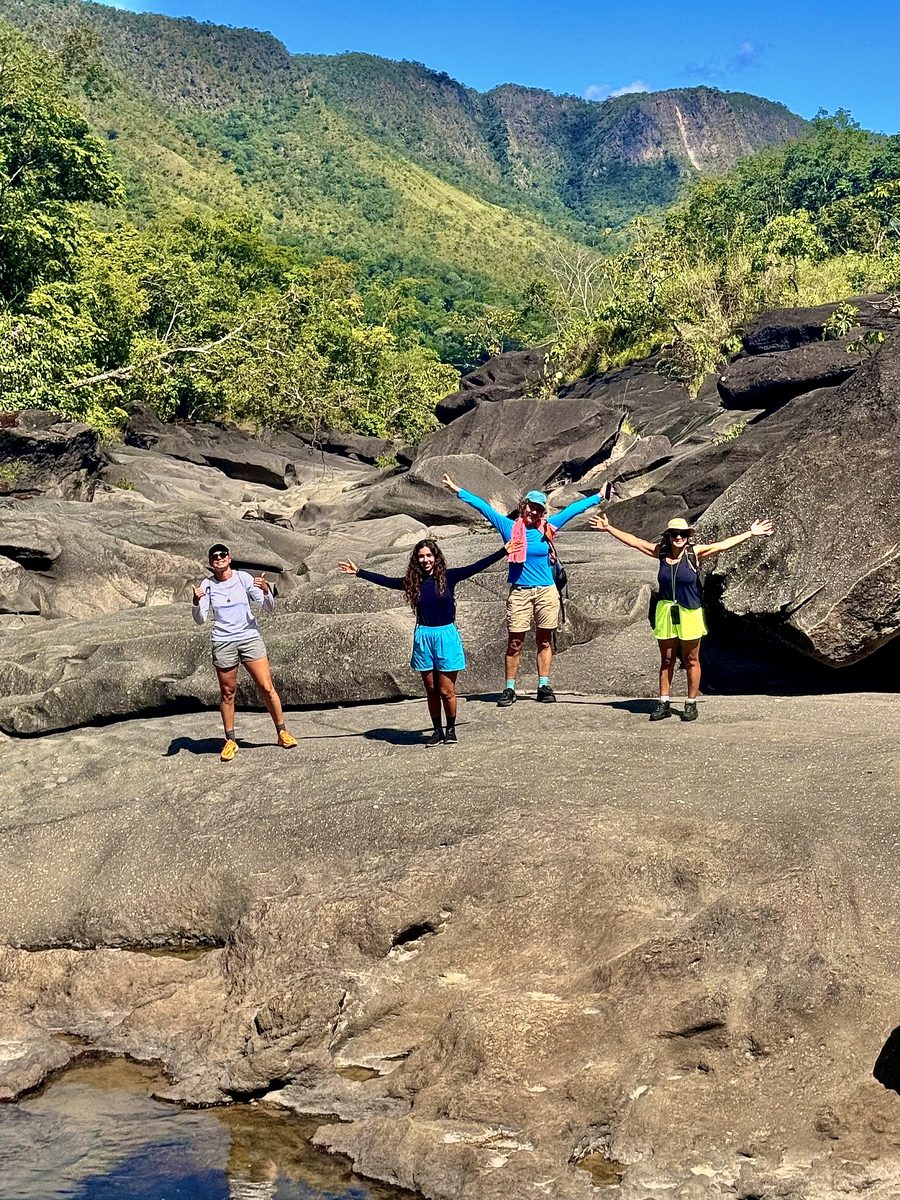 Grupo de braços erguidos sobre um platô com o cânion ao fundo