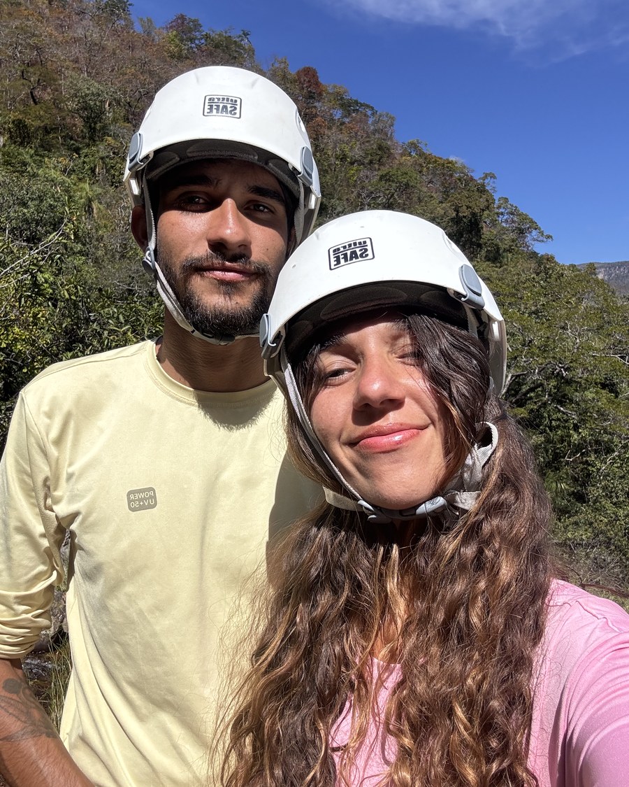 Dupla de guias sorrindo com capacetes de segurança, com a serra da Chapada ao fundo